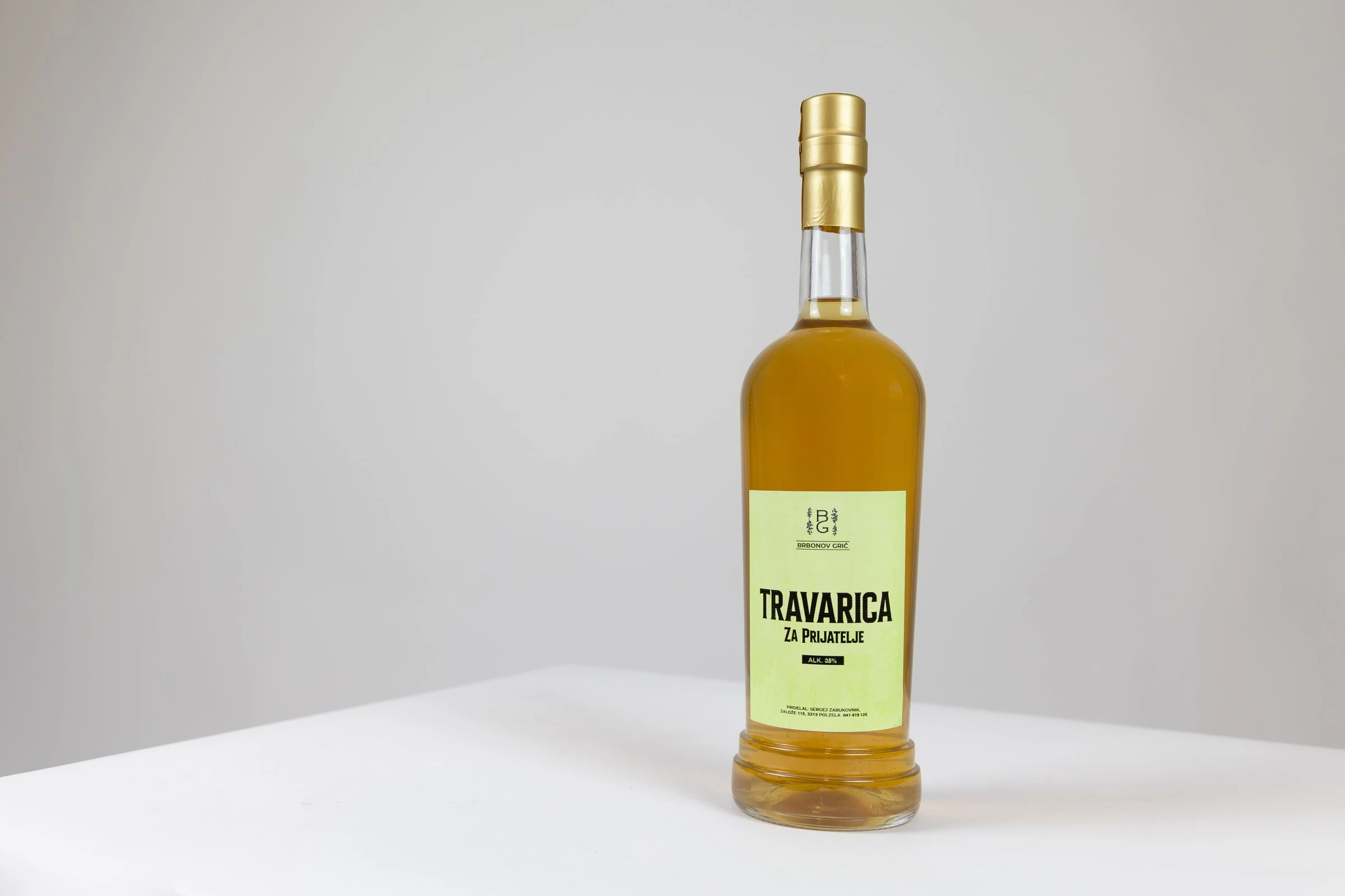 Steklenica travarice z zlato-zeleno etiketo